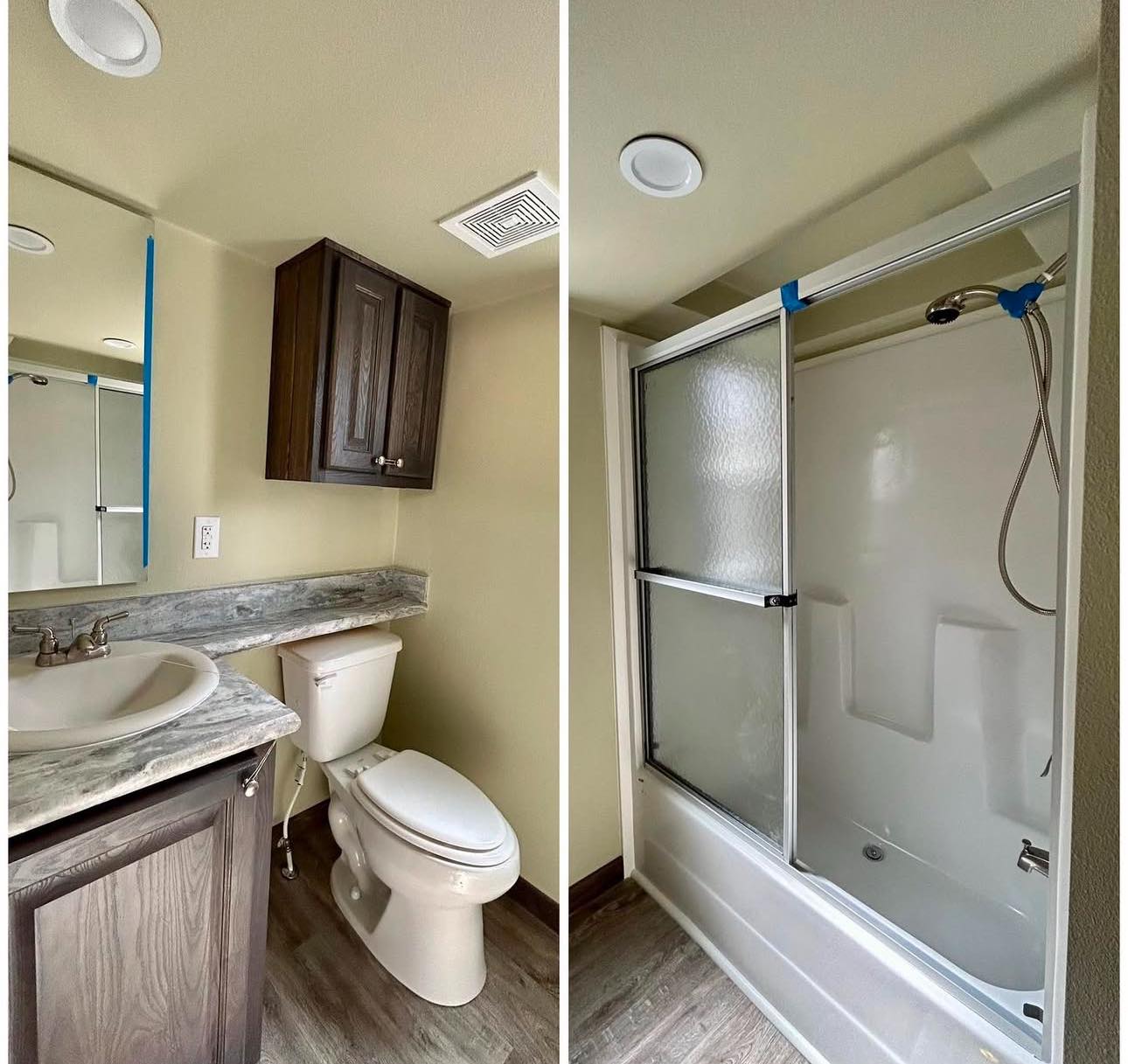 Compact bathroom with light brown tones, featuring a marble countertop, sink, toilet, dark wood cabinet, and glass-enclosed shower on wood-look flooring.