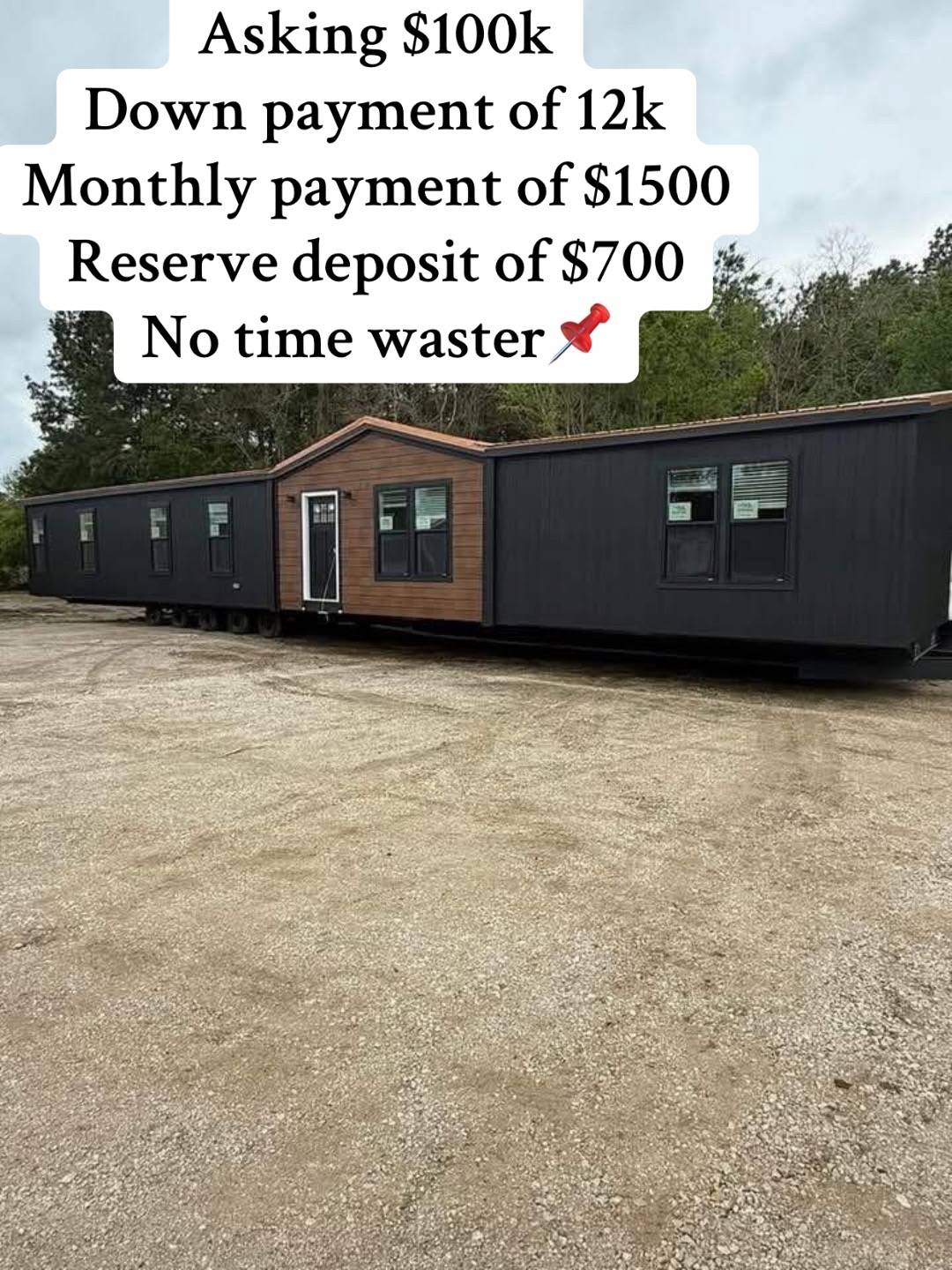 A large, modern black and wood-paneled mobile home is displayed on gravel. Text overlay lists payment details: $100k asking price, $12k down, and $1.5k monthly.