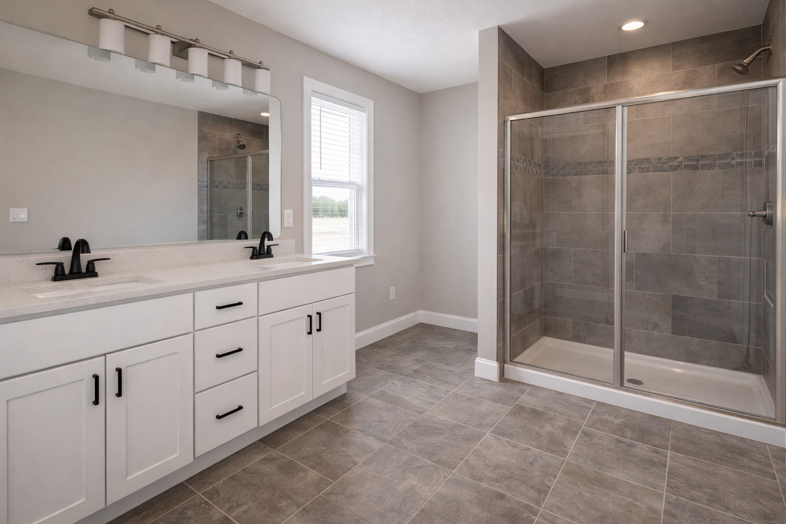 Spacious bathroom with a modern design, featuring a double sink vanity with white cabinets, black faucets, and a large walk-in shower with glass doors.