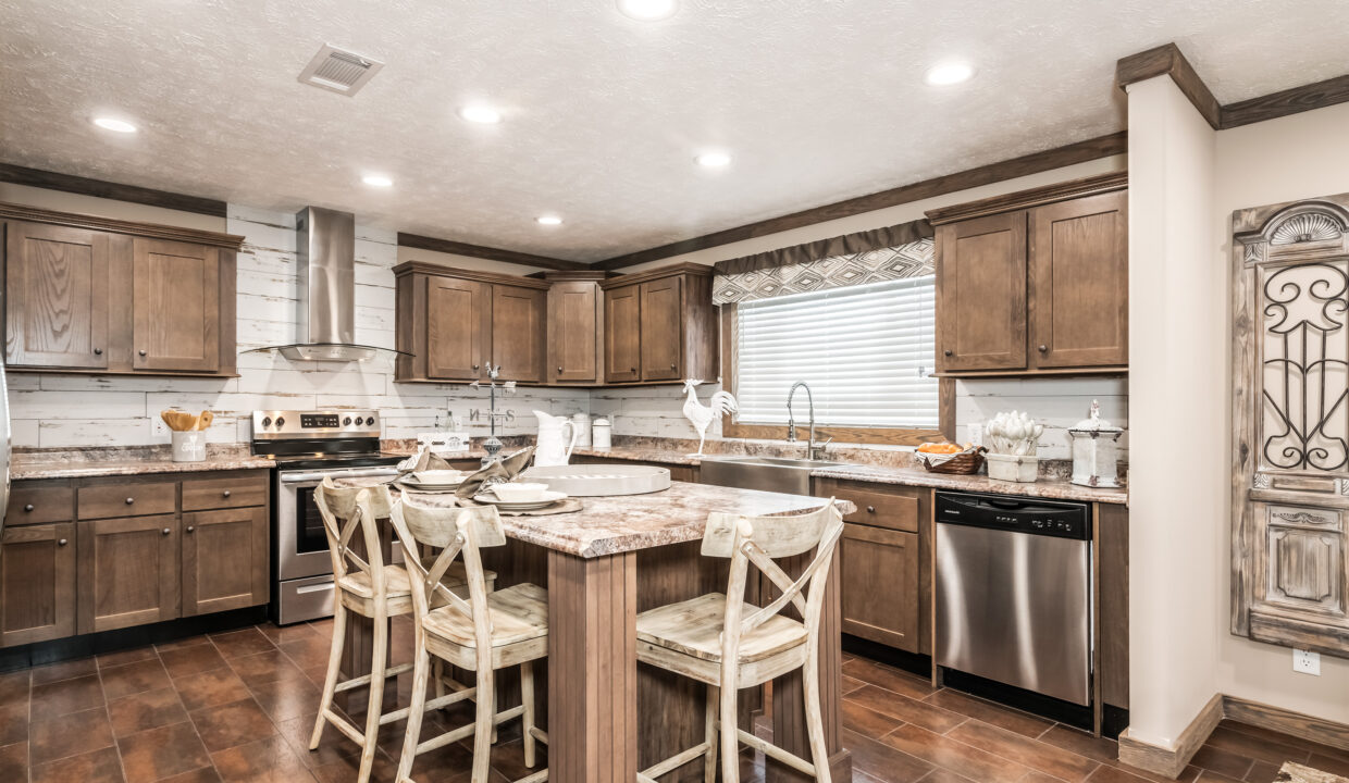 A rustic kitchen features wooden cabinets, a central island with barstools, stainless steel appliances, and soft lighting, creating a warm, welcoming atmosphere.