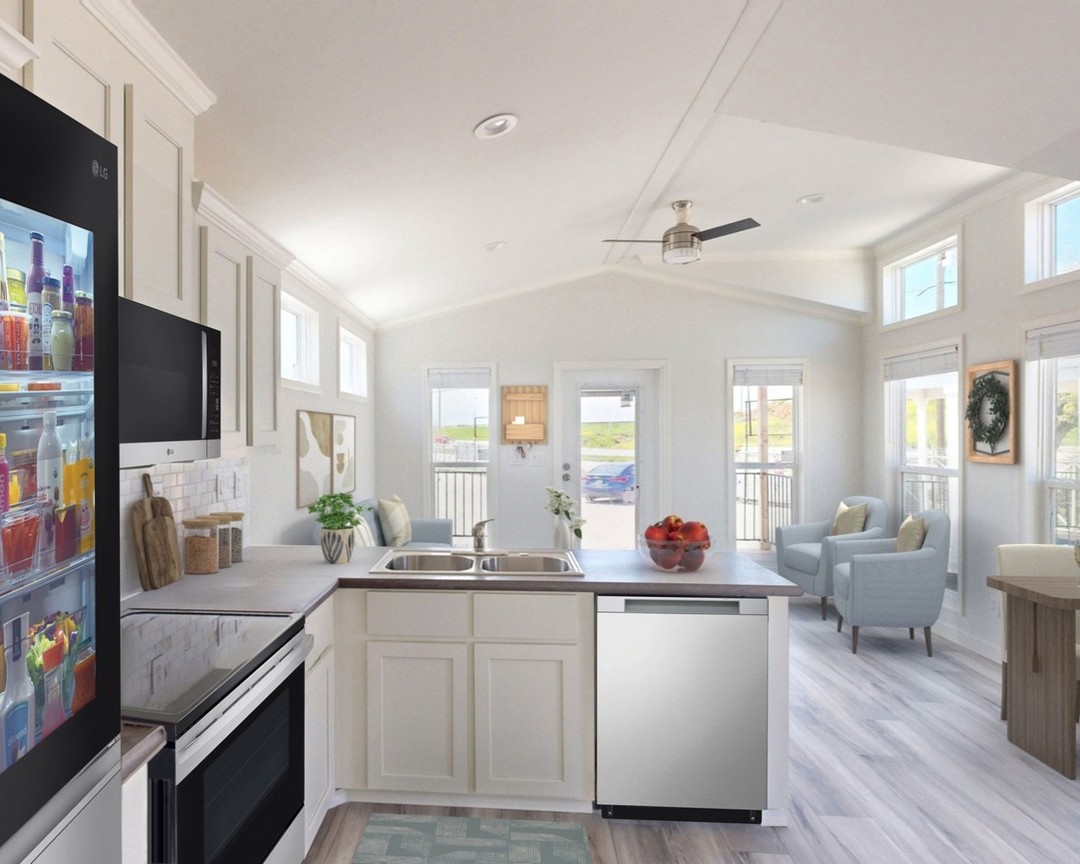 Bright, modern kitchen and living area; stainless steel appliances, light cabinets, fruit bowl on counter, light flooding in from large windows, airy ambiance.