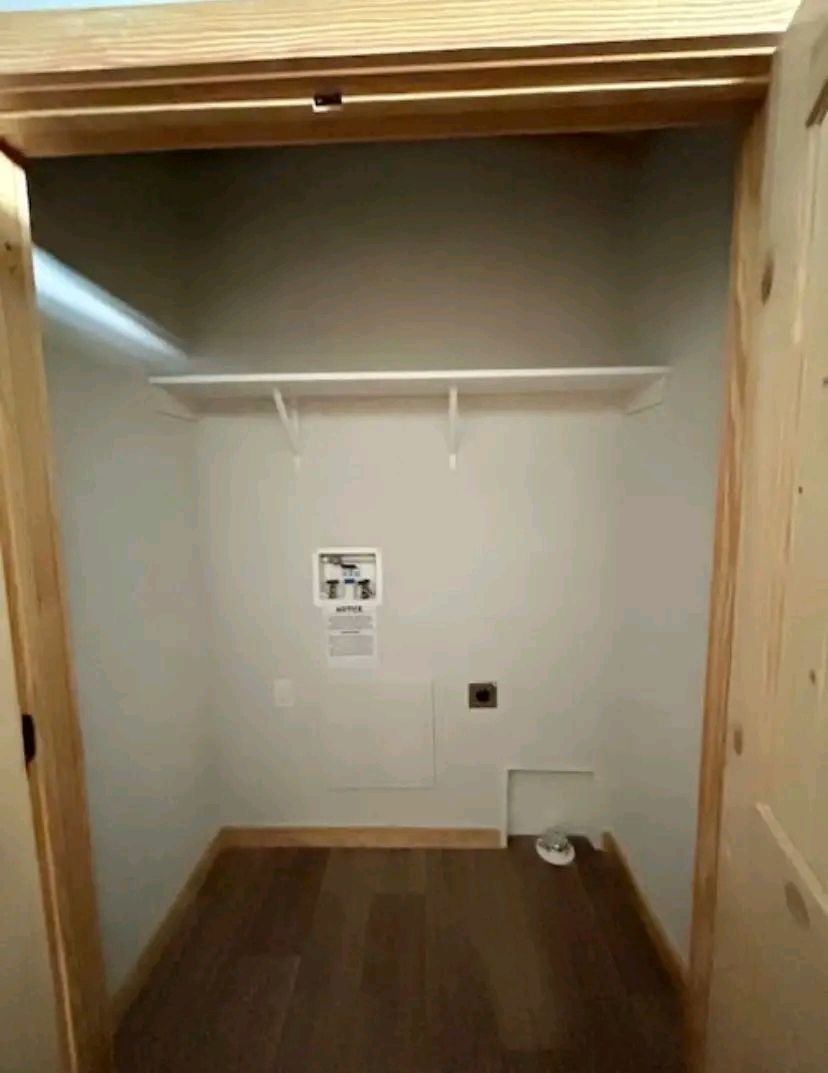 Empty closet with wooden trim, a single white shelf, light gray walls, and a hardwood floor. Simple and minimalistic with an unadorned, clean look.