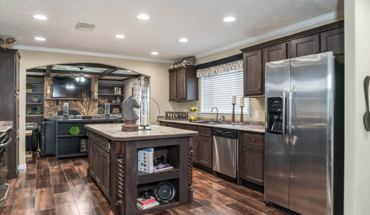 A spacious, modern kitchen with dark wood cabinets, stainless steel appliances, an island with decorative elements, and wooden flooring. Cozy and inviting.
